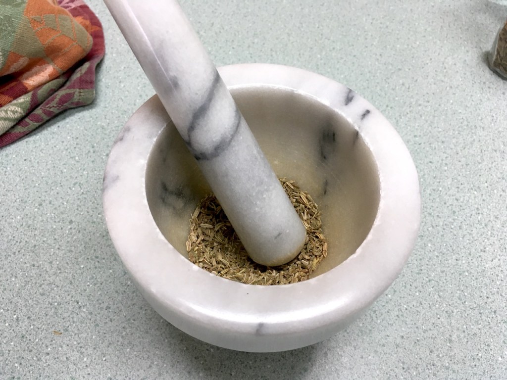 crushing fennel seeds mortar pestle